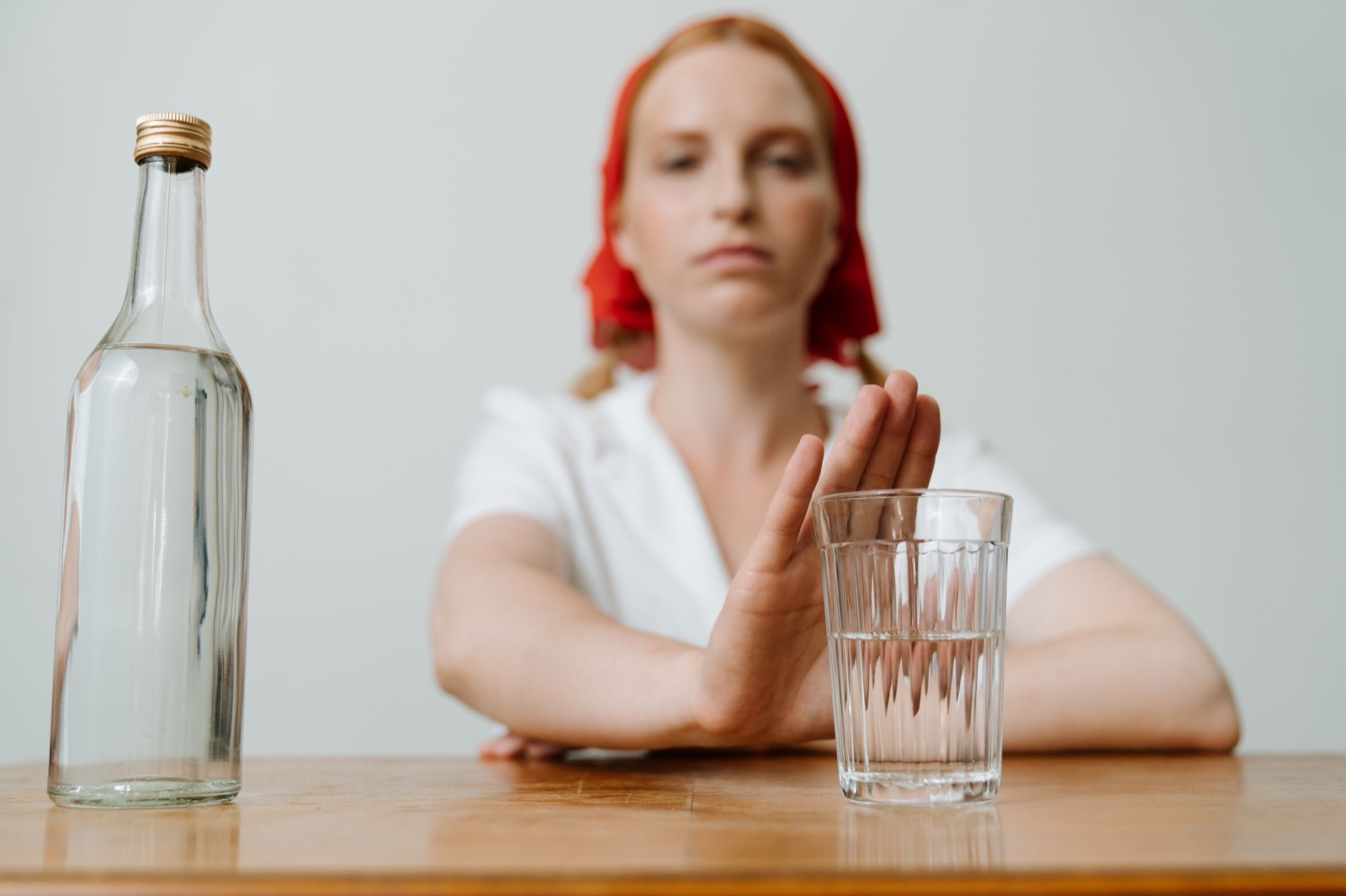 Person lehnt ein Glas Alkohol ab – Frage nach Abstinenz bei der MPU